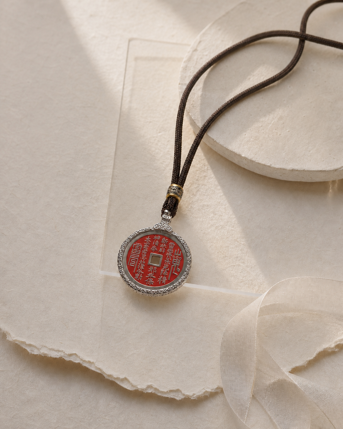 SHAN GUI Vermilion Guardian necklace arranged on textured ivory paper.