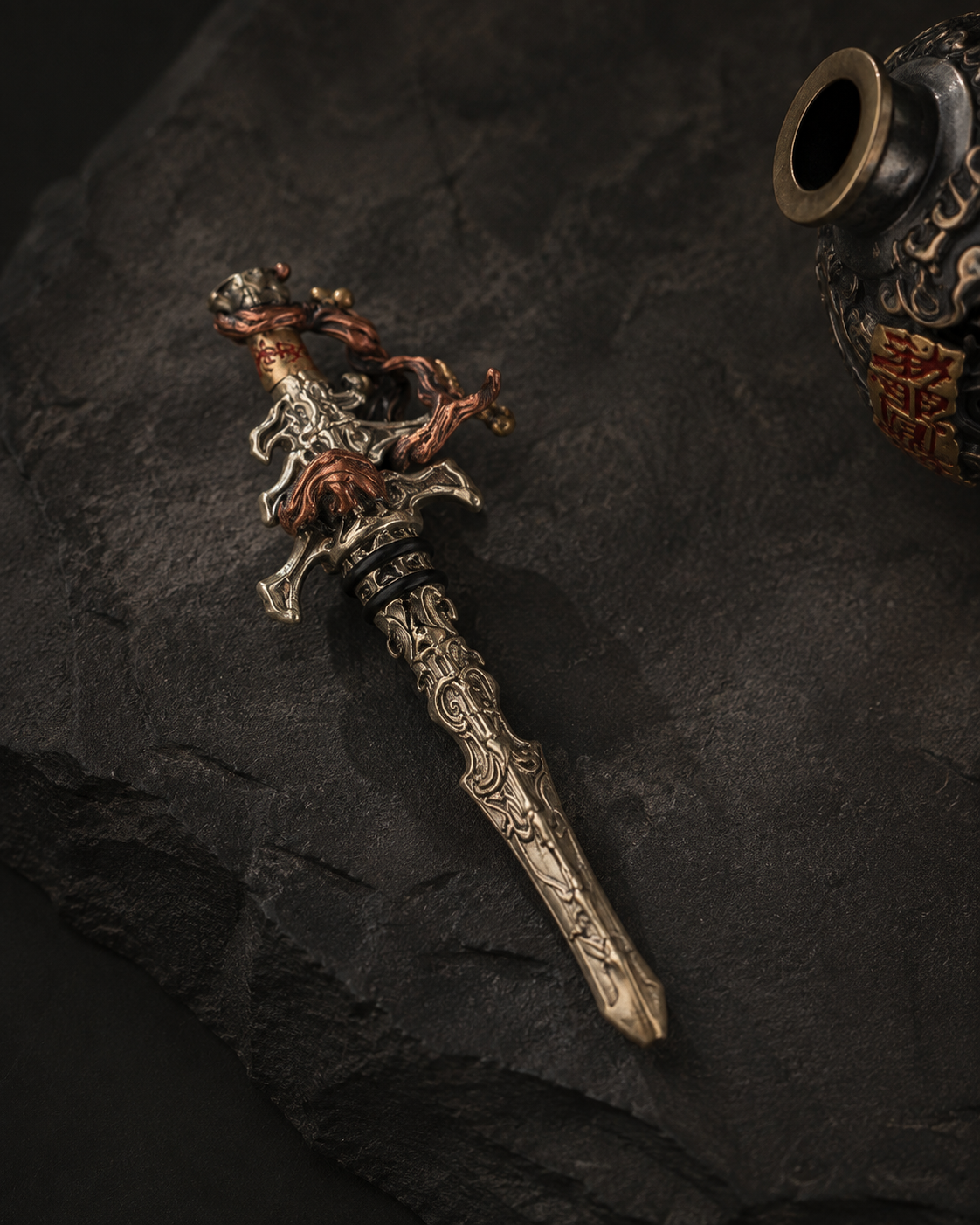 Removable decorative sword beside the open XUAN MO gourd on dark stone.
